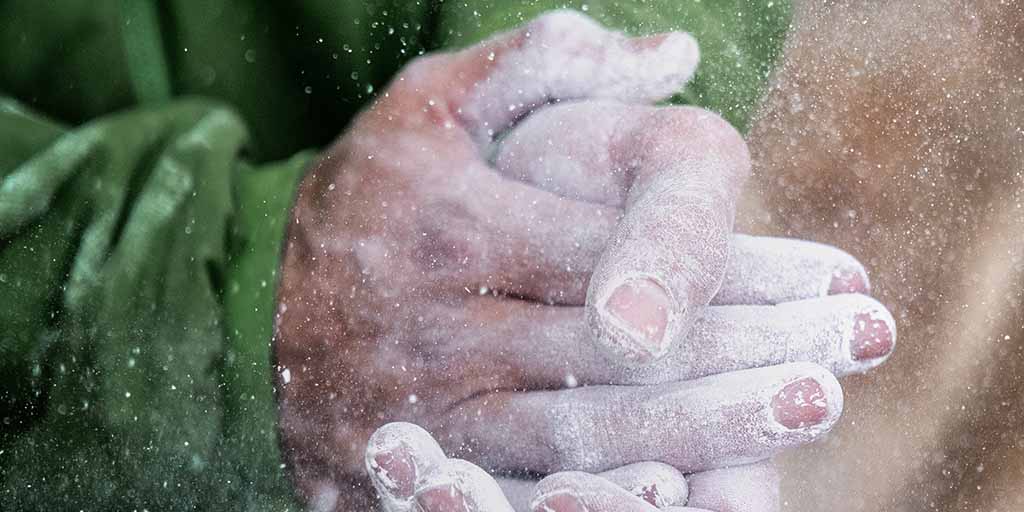 Fotografía detalle de manos juntas repartiéndose magnesio